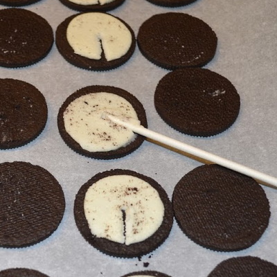 How to make oreo pops.  Make an impression with the lollipop stick.